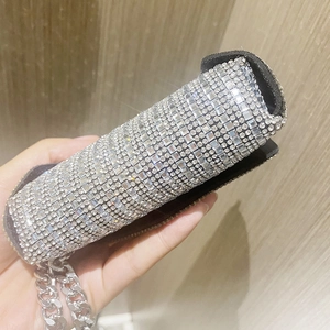 Close-up of a silver cylinder evening bag with sparkling rhinestones and a metal chain
