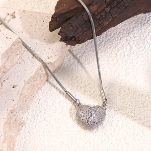 Macro shot of silver broken heart pendant with micro-pave crystals on snake chain