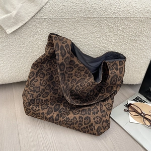 Close-up of large leopard print tote bag with soft suede texture on a cozy sofa