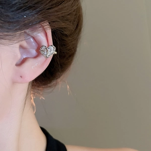 Close-up of double heart ear cuff with sparkling zircons worn by a model in silver