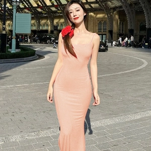 Detail view of a slim-fit pink sleeveless maxi dress with subtle shimmering fabric on a model