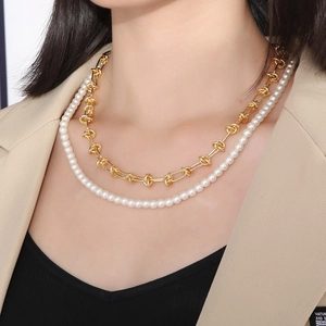 Collier double épaisseur en acier doré avec perles blanches porté par un mannequin