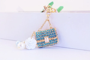 Detail of camellia flower bag keychain with blue rhinestones and pearl pendants