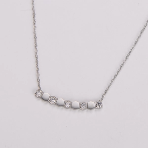 Dettaglio del ciondolo geometrico curvo con micro-pavé di zirconi cubici scintillanti