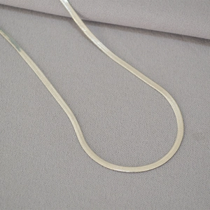 Detailed macro view of the silver herringbone chain showing smooth flat metal links
