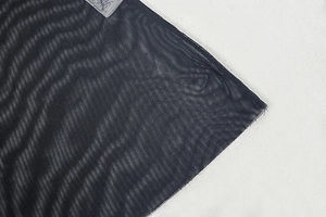 Detailaufnahme des schwarzen Netzgewebes und des Nackenetiketts eines Maxi-Kleides