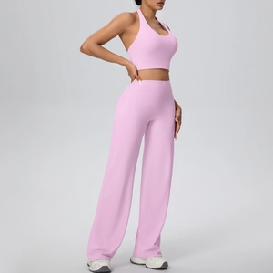 Detail of pink halter sports bra and high waisted wide leg yoga pants set on model