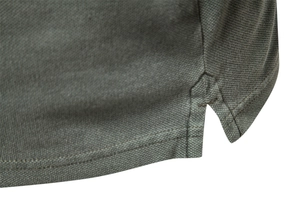 Macro view of olive green polo shirt side slit and piqué knit fabric texture
