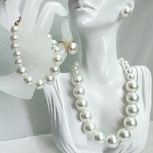 Detail of elegant white pearl jewelry set with necklace and bracelet on a display