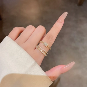 Three-piece gold plated layered ring set with sparkling zircon stones on female hand