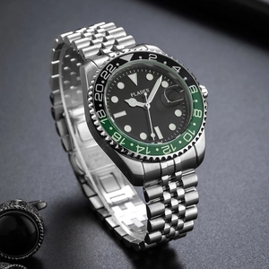 Classic stainless steel business watch with black dial and green-black bezel on grey surface