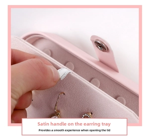 Macro shot of pink jewelry box earring panel with ribbon handle and soft suede interior