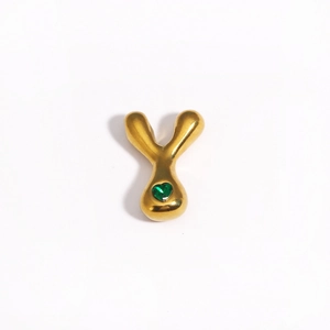 Gros plan du pendentif lettre Y doré avec une pierre précieuse cœur vert sur fond blanc