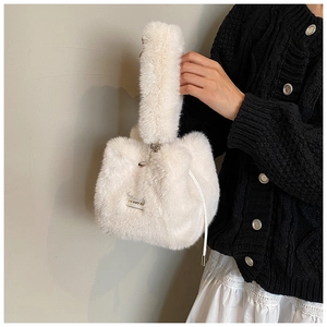 Detail view of a white faux fur bucket bag with drawstring and love every day tag