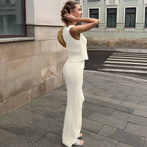 Set in maglia bianca alla moda con top senza maniche e pantaloni a vita alta su una modella