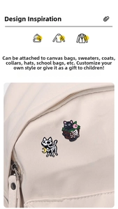 Detail of Halloween black cat skeleton and floral box enamel pins on a beige canvas bag