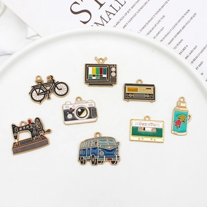 Flat lay of retro alloy enamel pendants including camera and sewing machine on a plate