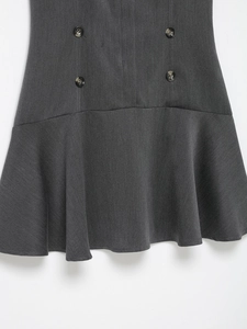 Détail d'une robe grise avec boutons ambrés à double boutonnage et ourlet volanté