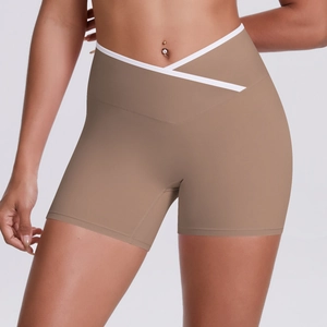 Close-up of high-waisted yoga shorts with V-shaped cross waist and white piping detail