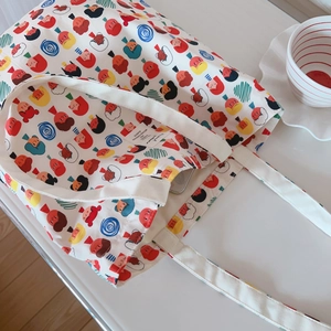 Vue de dessus d'un sac cabas en toile avec icônes de dessins animés sur table blanche