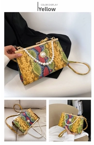 Détail du sac jaune à motif serpent avec poignées en perles et fermoir en métal doré