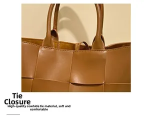 Detail view of brown woven leather tote featuring tie closure and cowhide texture