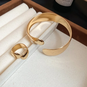 Macro shot of polished gold oval open bangle and matching ring in a velvet box