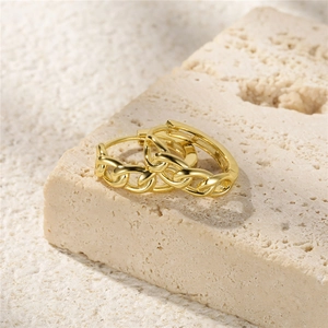 Macro shot of minimalist gold S925 sterling silver chain link hoop earrings on stone