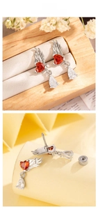 Detailed macro view of silver angel wing earring with red heart stone and screw-back post