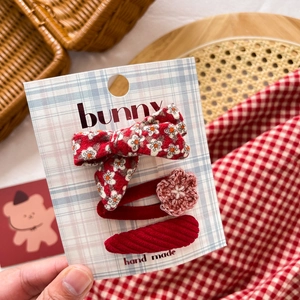 Detailed set of red fabric bow hair clips with floral patterns and crochet flower