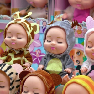 Macro detail of 5-inch sleeping baby dolls dressed in various soft animal-themed outfits