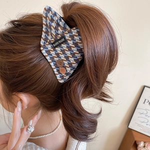 Detail of checkered fabric hair claw with buttons and hand made label in hair