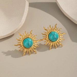Macro shot of gold sun-shaped stud earrings featuring vintage turquoise stone details