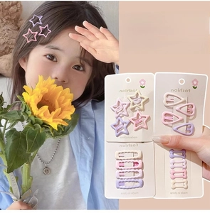 Detail view of colorful macaron star hair clips on model hair and packaging card