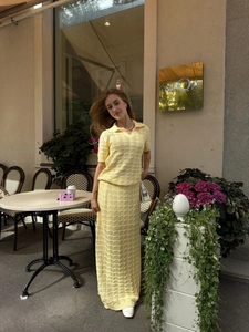 Detail of light yellow knit polo and skirt showing hollow-out crochet textures