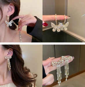 Detailed view of U-shaped silver earrings with pearls and long tassel diamond fringe