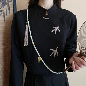 Detail of multi-layer pearl body chain with lotus pendant on black Chinese style top