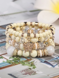Makro-Detail des böhmischen Perlenarmbands-Sets mit Kristallperlen und goldenem Schmetterling