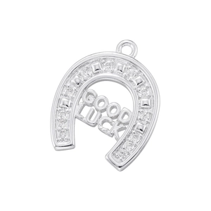 Macro shot of silver horseshoe pendant with GOOD LUCK engraving and zircon stones