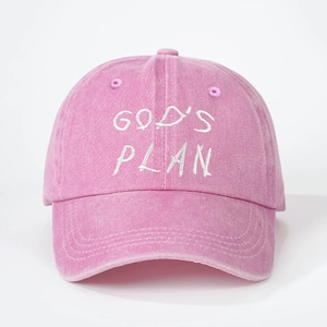 Close-up of pink washed cotton baseball cap featuring white GOD'S PLAN embroidery detail