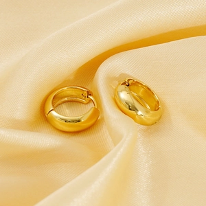 Polished 18K gold plated stainless steel hoop earrings on elegant silk fabric