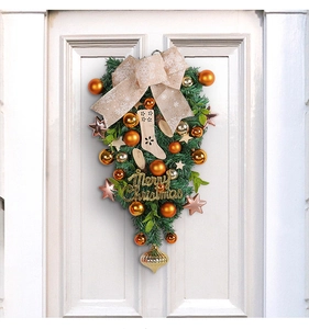 Detail of Christmas teardrop wreath with gold Merry Christmas sign and bows
