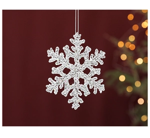 Close-up of glittery white snowflake ornament with festive bokeh background lighting