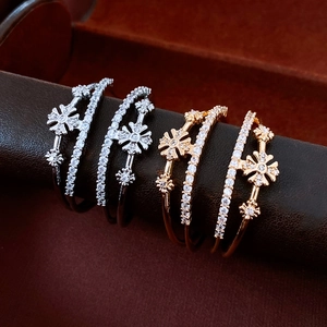 Detailed shot of gold and silver flower double-layered bangles with zircon inlay