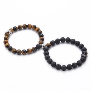 Detail view of magnetic couple bracelets with tiger eye, lava stone and crown charms