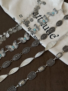 Detail of bohemian silver waist chains featuring turquoise butterflies and coin charms