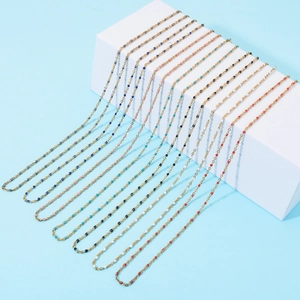 Bohemian gold chain bracelets with colorful tiny beads displayed on a white stand