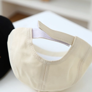 Close-up of adjustable Velcro strap on beige cotton beret for toddlers with quality stitching