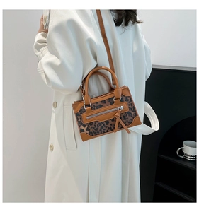 Chic leopard print handbag styled with a white trench coat in a modern home setting