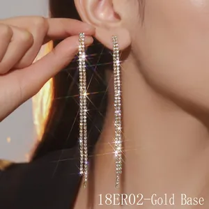 Detailed view of long gold-base tassel earrings with sparkling rhinestones on model